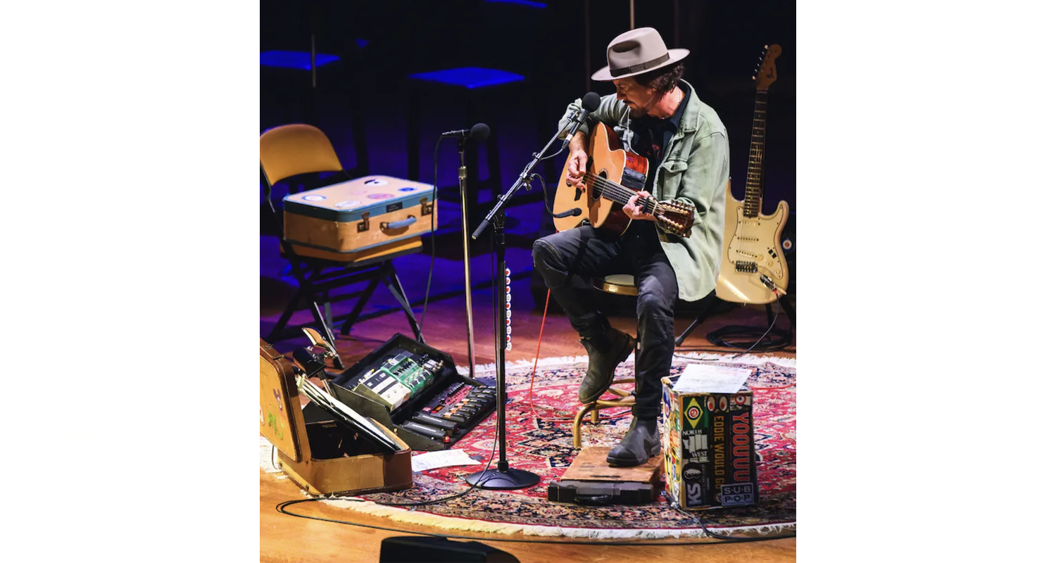Rugs and Rockers: The Strange Bond Between Persian Rugs and Rock’n’Roll 5 Eddie Vedder performing an intimate solo acoustic set, anchored by his signature round rug and vintage suitcase.