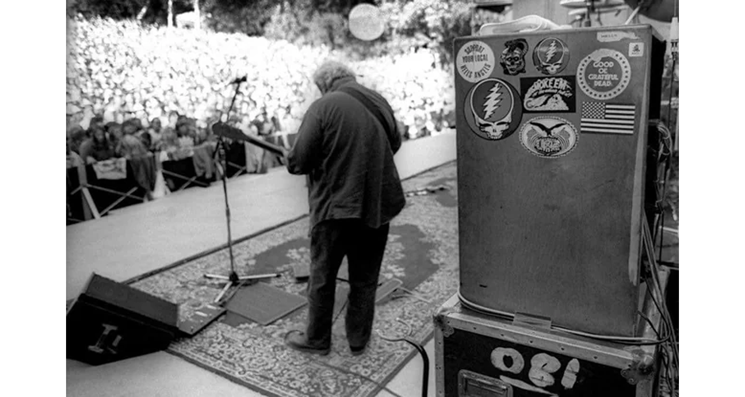 Rugs and Rockers: The Strange Bond Between Persian Rugs and Rock’n’Roll 20 Jerry Garcia performing from behind his guitar rig atop a weathered, geometric Persian stage rug during an outdoor Grateful Dead concert (c. 1989).