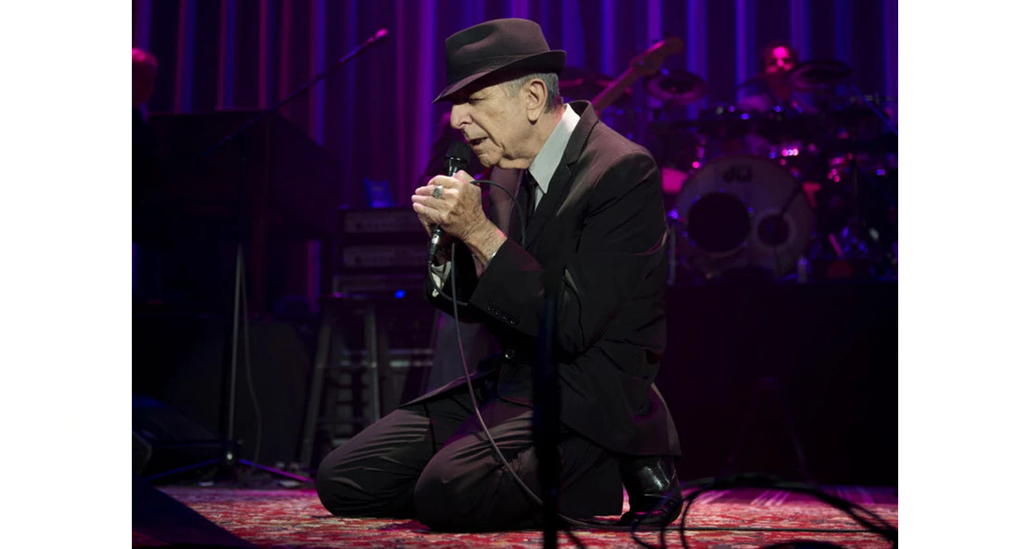 Rugs and Rockers: The Strange Bond Between Persian Rugs and Rock’n’Roll 21 Leonard Cohen kneeling on a red Persian stage rug during a live performance (c. 2008–2013). Cohen frequently adopted this posture to acknowledge accompanying musicians during their solos and perform quieter passages.