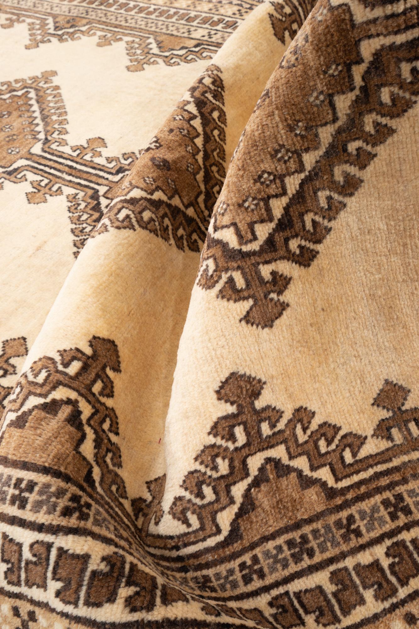 Ivory wool pile and hooked brown medallion detail of the Shooli Gabbeh rug
